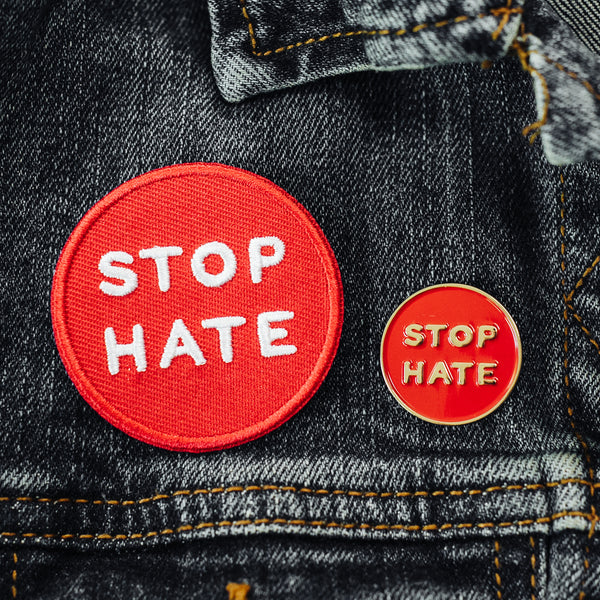 Stop Hate embroidered iron on patch and enamel lapel pin on a jean jacket