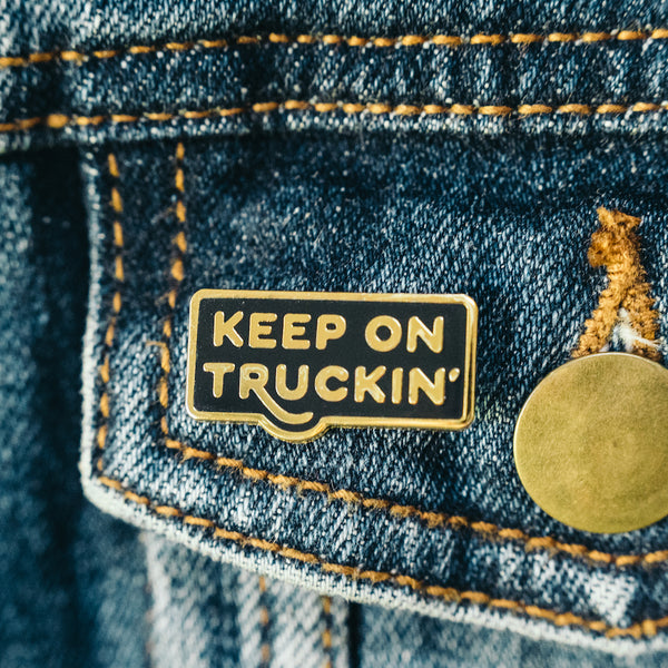 Keep on truckin retro style enamel lapel pin on jean jacket