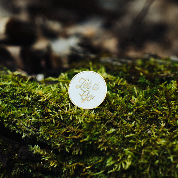 let it go self care enamel pin on green moss