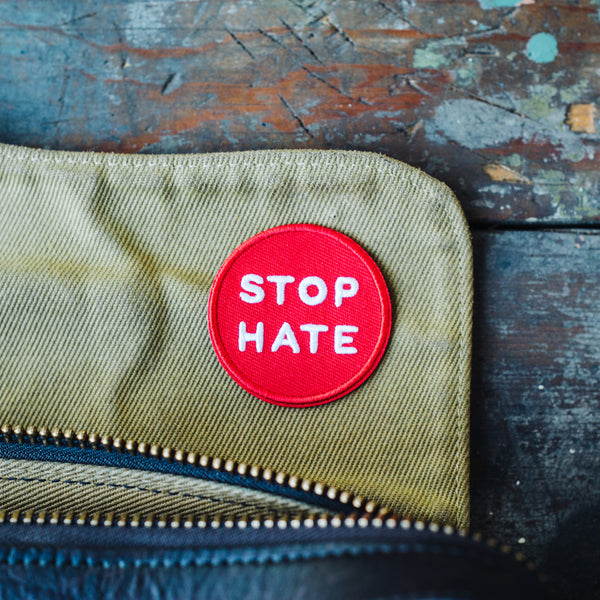 Stop hate embroidered iron on jacket patch on a Filson bag